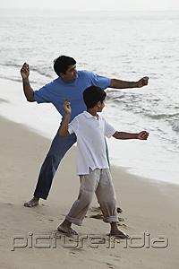 PictureIndia - Father and son throwing rocks into the water