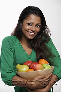 PictureIndia - Woman wearing green top holding bowl of fruit