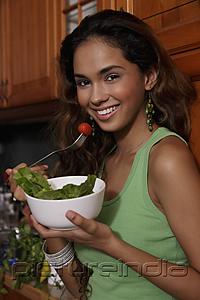 PictureIndia - Young woman eating salad and smiling
