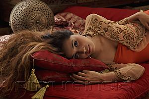 PictureIndia - Young woman laying down on Indian pillows