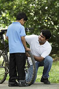 PictureIndia - Father and son fixing bike together