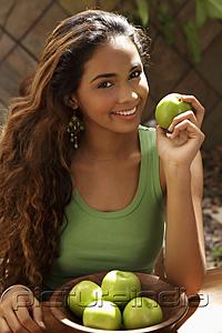 PictureIndia - Young woman with bowl of green apples smiling