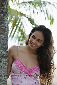 PictureIndia - young woman smiling with long hair next to coconut tree