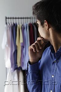 PictureIndia - side view of young man looking at shirts