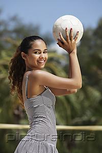 PictureIndia - young woman holding volleyball and smiling at camera