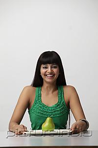 PictureIndia - woman holding plate with green pear and smiling
