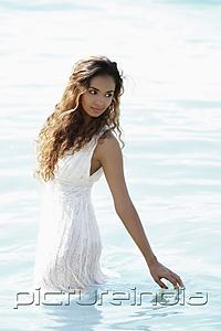 PictureIndia - young woman wearing a white dress and standing in water