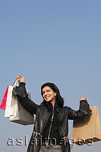 Asia Images Group - woman with shopping bags raised in air