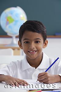 Asia Images Group - boy at desk with blue pencil