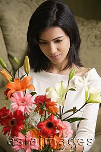 Asia Images Group - woman looks down at bouquet of flowers