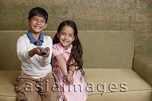 Asia Images Group - girl and boy on couch with tv remote