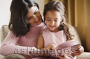 Asia Images Group - mother reads story book to her daughter