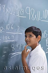 Asia Images Group - boy at chalkboard, finger on chin