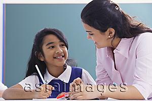 Asia Images Group - teacher and student smile at each other