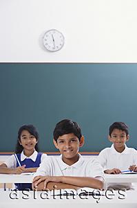 Asia Images Group - three students smile at camera, boy in center, arms folded