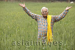 Asia Images Group - farmer in field, hands in air