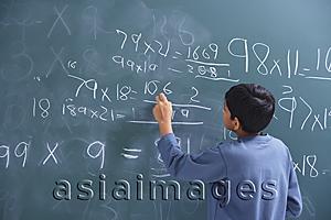 Asia Images Group - boy working at chalkboard (back view)