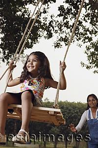 Asia Images Group - mother pushing girl on swing