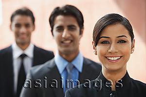 Asia Images Group - smiling businesswoman, two businessman in background