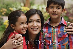 Asia Images Group - mother with arms around son and daughter, all smiling at camera