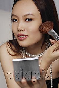 AsiaPix - Young woman applying blush