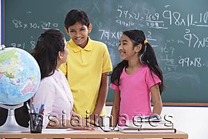 Asia Images Group - teacher speaking to two students, students smiling