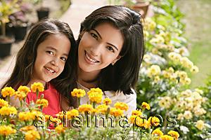 Asia Images Group - mother and daughter with flowers, smiling at camera