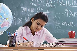 Asia Images Group - teacher working at desk