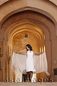 Asia Images Group - woman walking with shawl in arched hallway