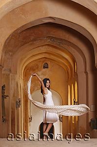 Asia Images Group - woman with scarf in arched hallway
