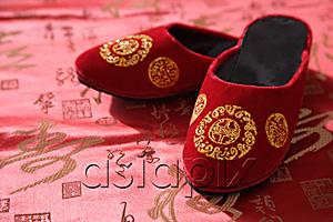 AsiaPix - Still life of pair of red shoes on oriental design fabric