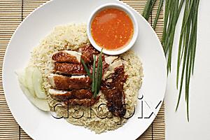 AsiaPix - chicken rice with chili sauce on the side on white plate