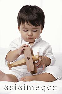 Asia Images Group - baby boy playing with toy airplane