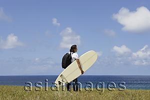 Asia Images Group - man holding surf board, looking out to sea