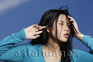 Asia Images Group - young lady glancing sideway, hands on head