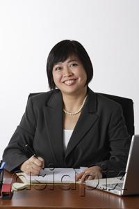 AsiaPix - business woman sitting at desk smiling