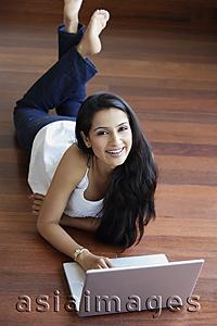 Asia Images Group - young woman on floor using laptop