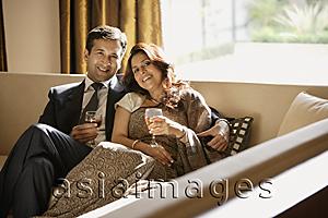Asia Images Group - couple on couch holding glasses of wine