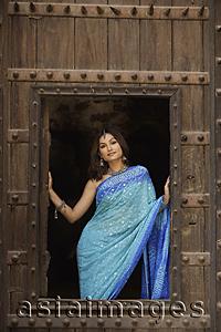 Asia Images Group - young woman in sari, posing from window