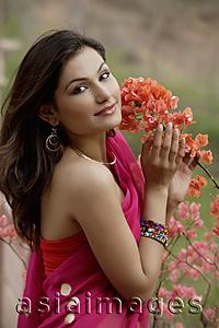 Asia Images Group - young woman in sari holding flowers