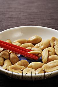 AsiaPix - close up of red chopsticks picking up peanuts