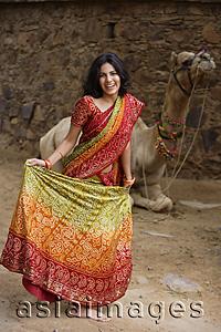 Asia Images Group - young woman in sari, in front of camel