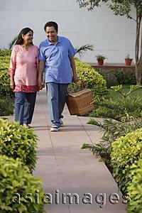 Asia Images Group - couple walking on path with picnic basket