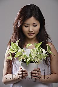 AsiaPix - Chinese woman holding green plant