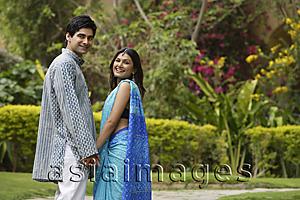 Asia Images Group - young couple in garden, turning back smiling