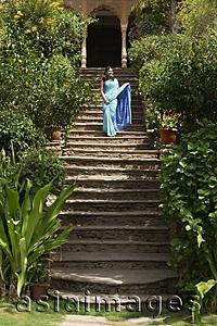 Asia Images Group - young woman in sari, standing on stairs