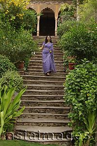 Asia Images Group - young woman in sari walking down the stairs