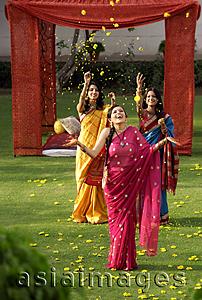Asia Images Group - three women wearing saris in front of tent