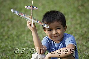 Asia Images Group - boy holding toy airplane