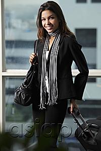 AsiaPix - young woman holding bag and pulling suitcase